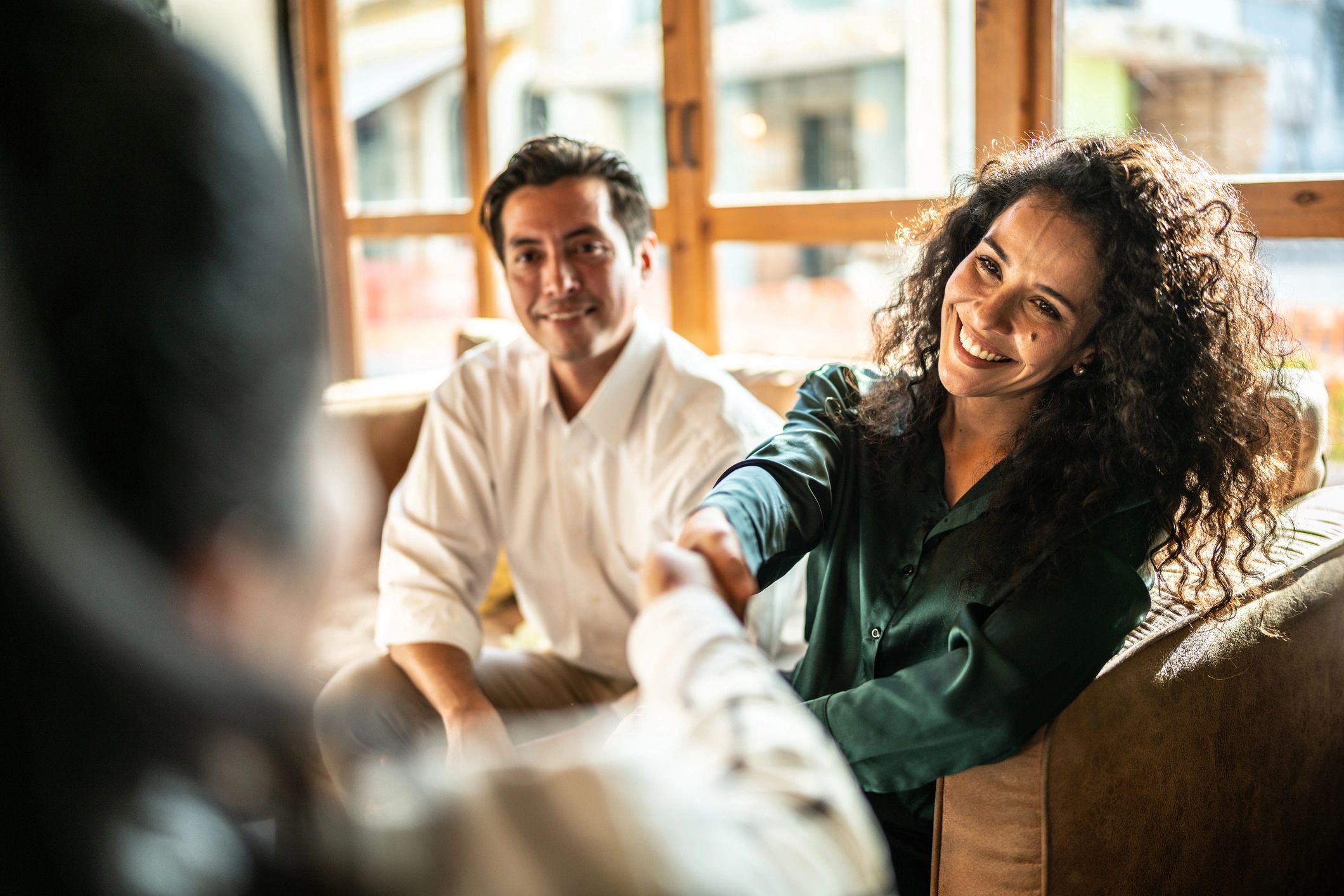 Advisor shaking hands with clients in a living room
