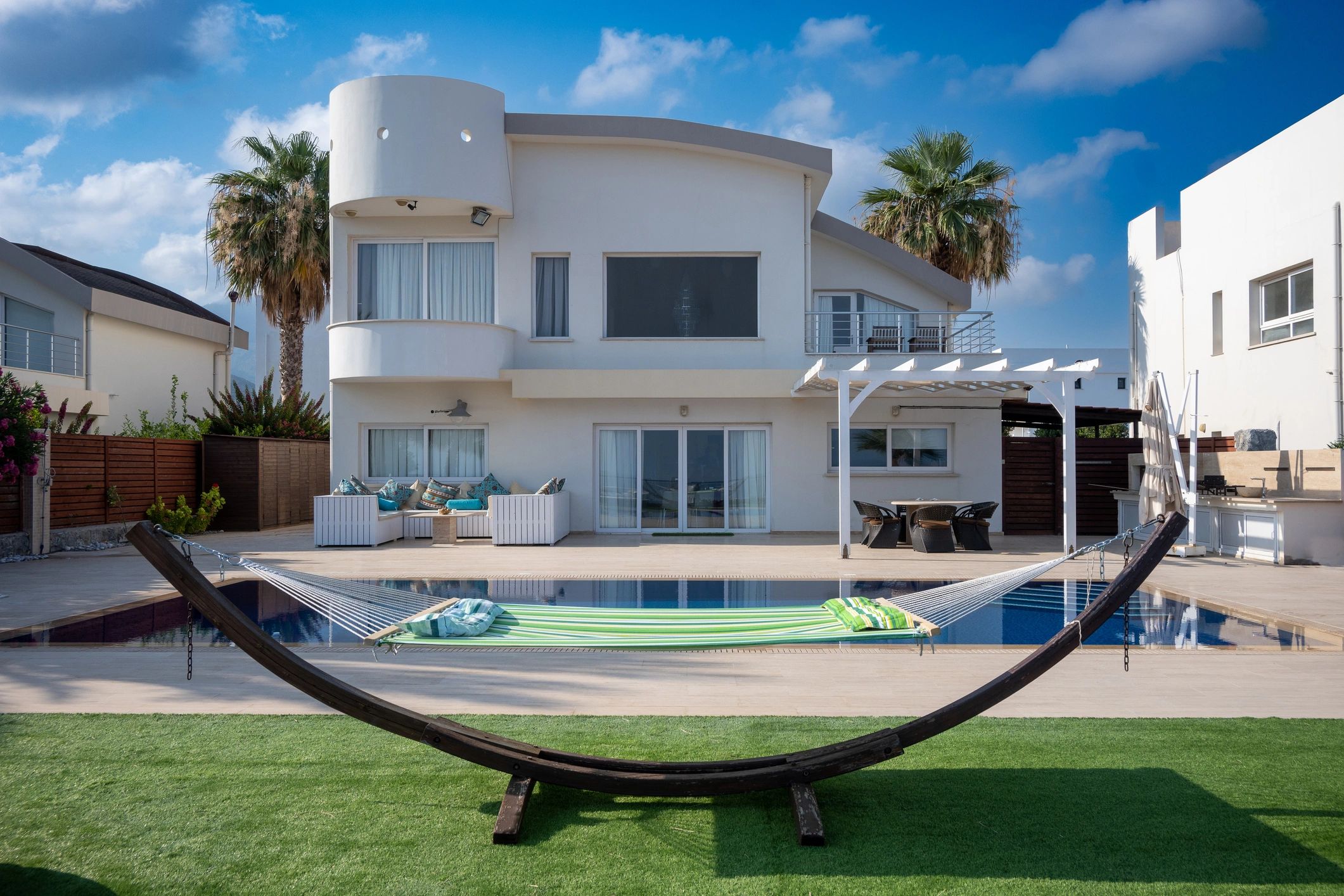 White villa with pool and hammock