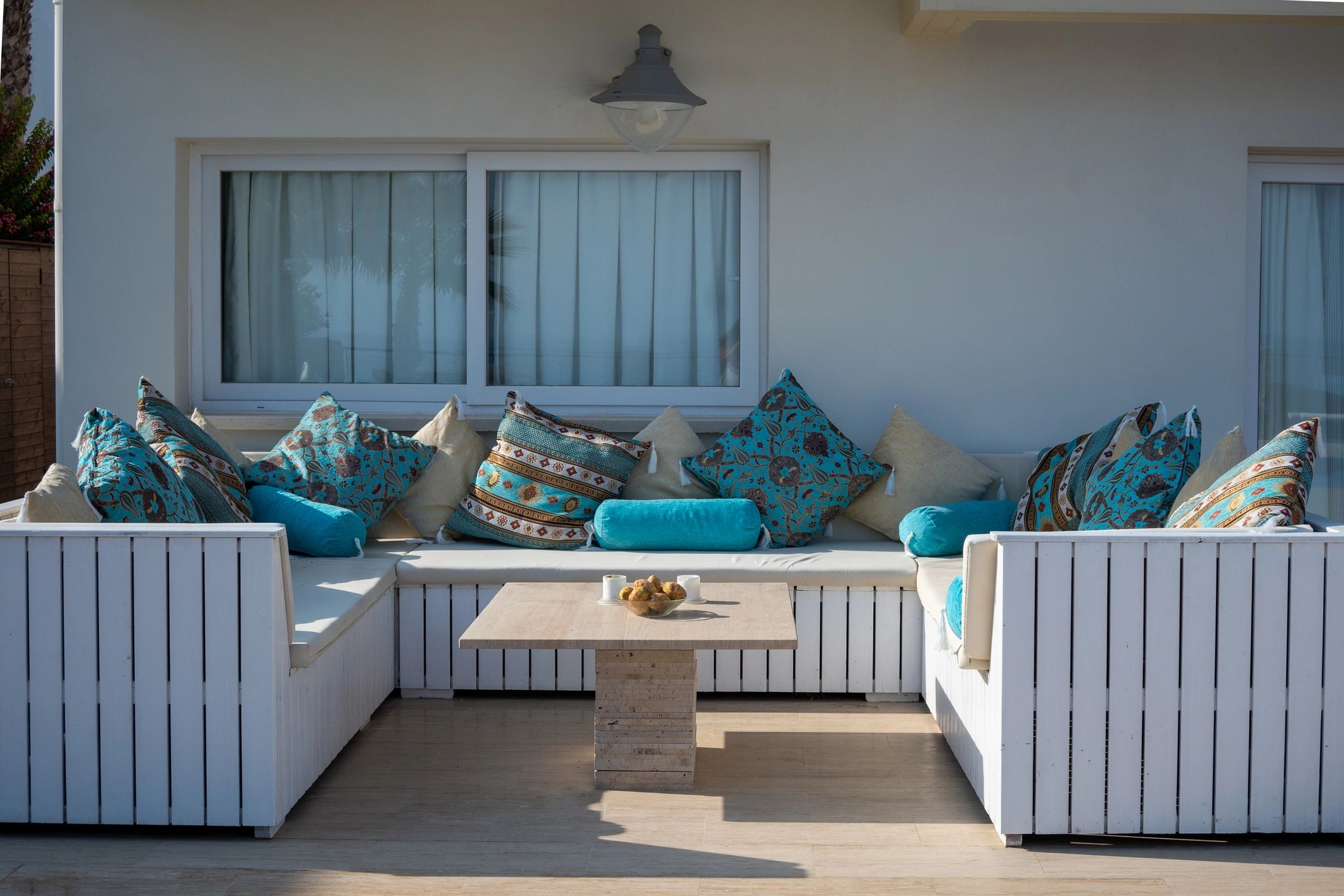 White villa patio furniture with turquoise cushions