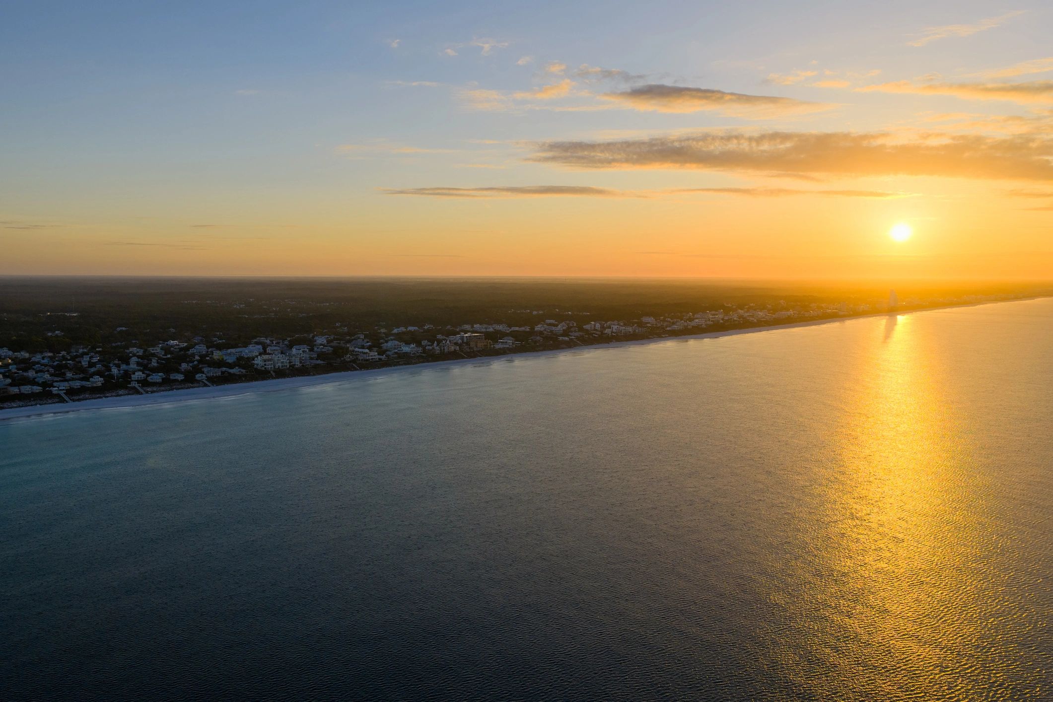 Seaside, Florida coastline at sunset during spring. Aerial view of residential waterfront community along Atlantic Ocean.
